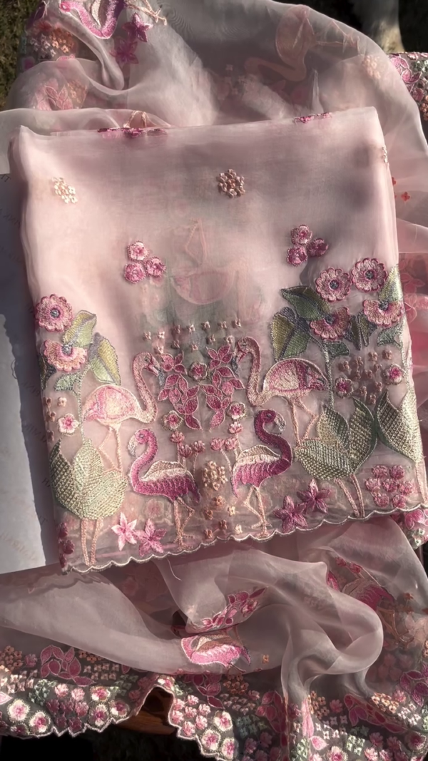 Light Pink Organza Embroidered Fabric Featuring Intricate Flamingo and Floral Motifs with Multicolor Threadwork, Scalloped Edges, and Delicate Handcrafted Details – Ideal for Festive Wear, Formal Attire, or Statement saree
